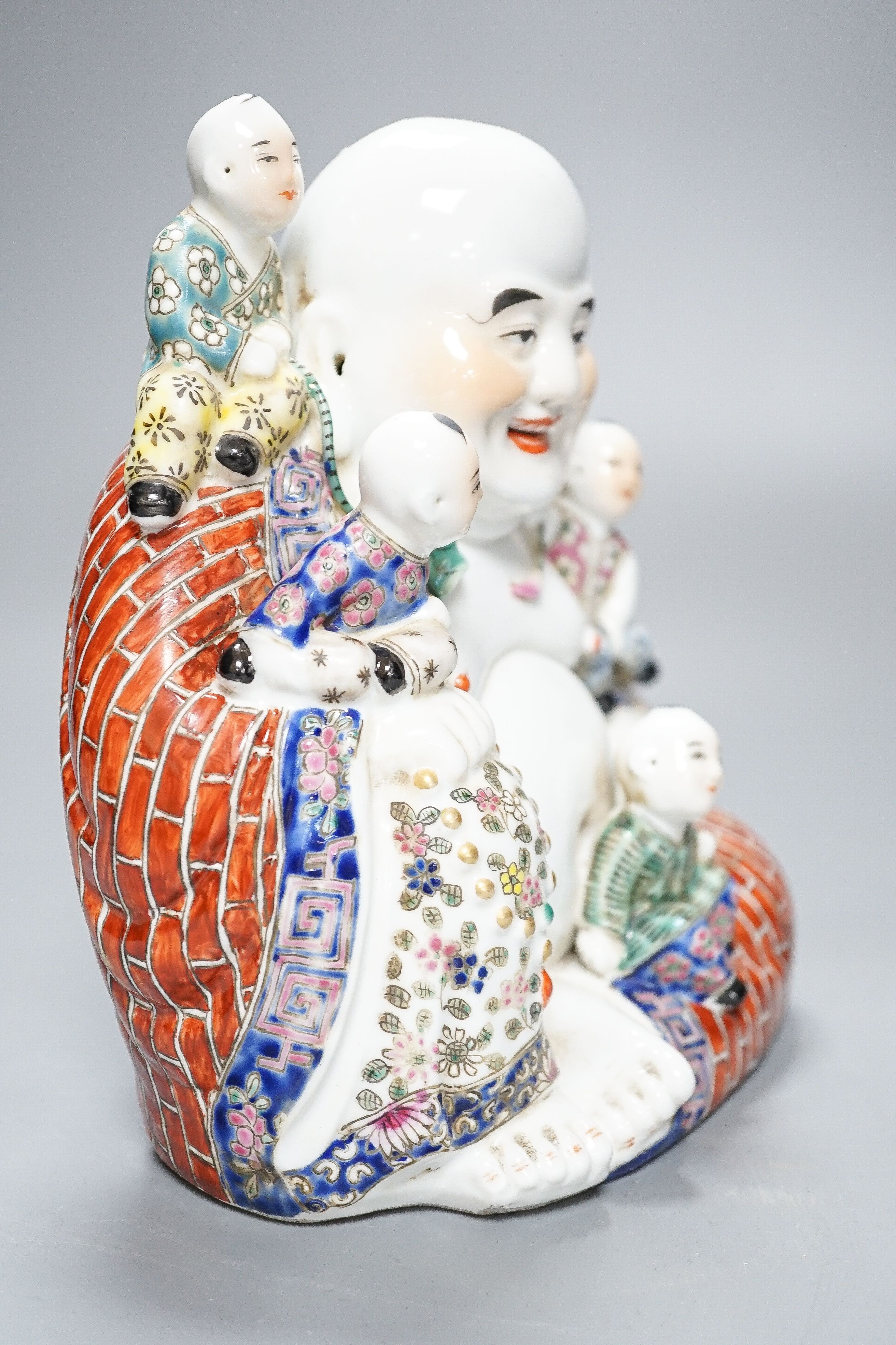 A Chinese enamelled porcelain group of Budai and boys, 19cm high